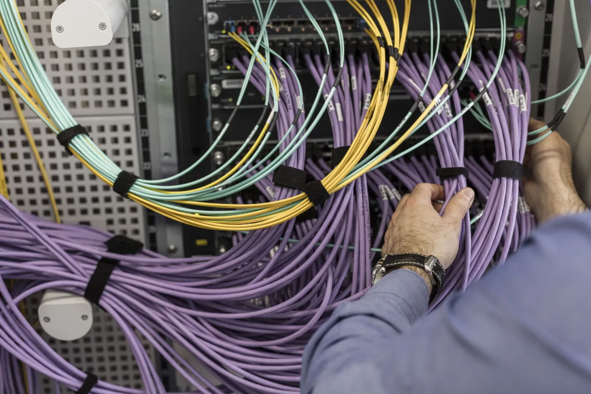 Technician working on network cabling in a data center